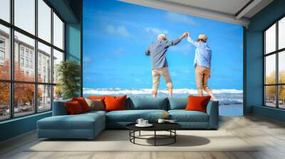 Plan life insurance of happy retirement concepts. Senior couple dancing at the beach looking the ocean on a good day in sunny day morning. Wall mural