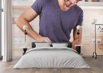 Young man preparing food at home Wall mural