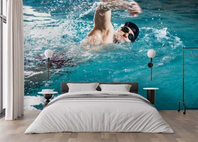 Young man swimming the front crawl in a pool Wall mural