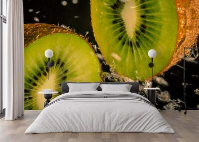 Sao Paulo, SP, Brazil - August 16 2022: Kiwi slices and water splashing on a black background details. Wall mural