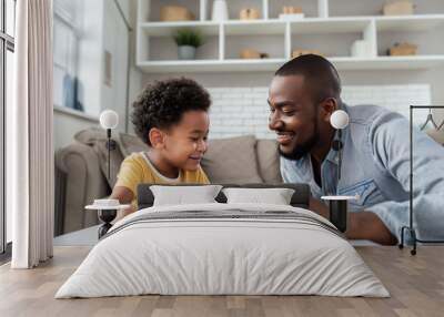 Bonding over board games, African American father and son enjoy quality time at home. Wall mural