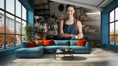 I cant wait to be at your service. Shot of a young woman working in a coffee shop. Wall mural