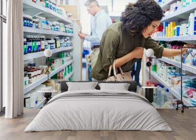 Pharmacy, shopping and woman with medicine check and product in a retail store. Pharmaceutical, drugs and pills with a African female person looking at box for ingredients and information in shop Wall mural