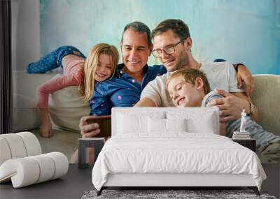 Get in here, were taking a selfie. Cropped shot of an affectionate family of four taking selfies on the sofa at home. Wall mural