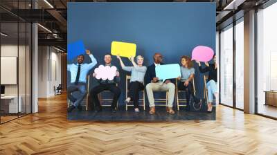 It feels good being able to speak your mind. Shot of a group of people holding up speech bubbles against a blue background. Wall mural