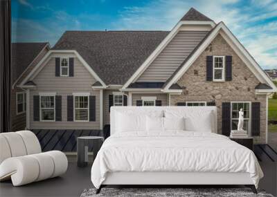 Aerial view of complex facade with stone veneer covered gable 2 jerkin head pitched roof, gray horizontal vinyl siding, dark shutters on the white frame elegant double sash windows single family home Wall mural