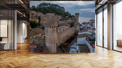 Aerial view of popular Costa Brava vacation beach town Tossa de Mar near Barcelona Spain with medieval walls, towers and stormy cloudy sky in the background Wall mural