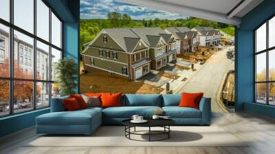 Elevated view of almost finished luxury townhouses with two single car garages, brick and shake and shingle siding, gable roof with attic vent on a new residential development in Maryland USA Wall mural