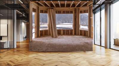 Interior view of a semi circular sun room  letting in a lot of light, plywood floors and room skeleton structure at a new American real estate development construction site Wall mural