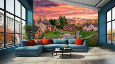 Neighborhood street sunset panorama of modern upper middle class single family houses American real estate in a new construction in Maryland USA colorful dramatic sky Wall mural