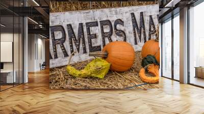 Yellow and orange pumpkins on hay stack on a farm for halloween decoration in America with farmers market sign Wall mural