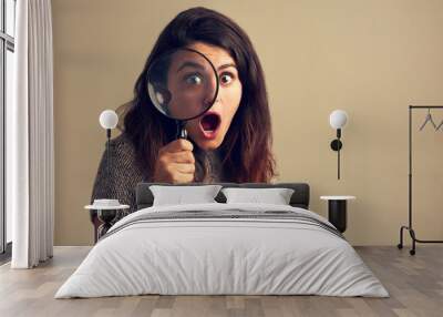 Girl, portrait and surprise with magnifying glass in studio for investigation on bargain for price saving and retail discount. Spy, loupe and inspection with shock on background for fashion deal. Wall mural