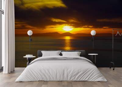 Sky on fire during sunrise or sunset twilight over the Mediterranean Sea with mountain coast silhouette on horizon during romantic scenic cruising during dream vacation on cruiseship liner Wall mural