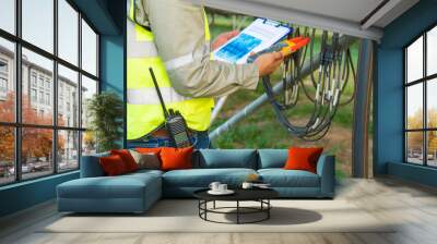 Portrait of engineer man or worker, people, with solar panels or solar cells on the roof in farm. Power plant with green field, renewable energy source in Thailand. Eco technology for electric power. Wall mural