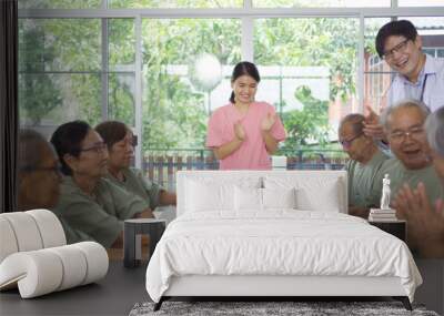 Portrait of happy group of old elderly Asian patient or pensioner people with a nurse and doctor playing games in nursing home. Senior lifestyle activity recreation. Retirement community. Health care Wall mural