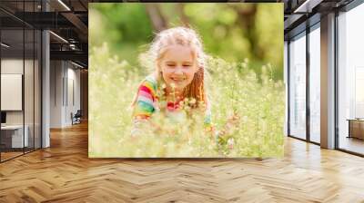 Child resting on green field Wall mural