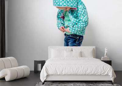 little girl fastening her blue jacket Wall mural