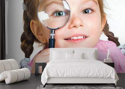 little girl looking through a magnifier Wall mural