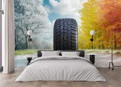 All-Season Tire on a Snowy Road with Winter, Spring, Summer, and Fall Trees in the Background, Representing the Ability to Drive Safely in Any Weather Wall mural