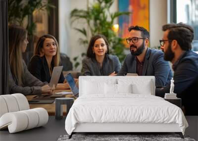 A group of people are sitting around a table with laptops and tablets Wall mural