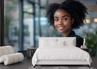 A woman with curly hair is smiling and holding a tablet Wall mural