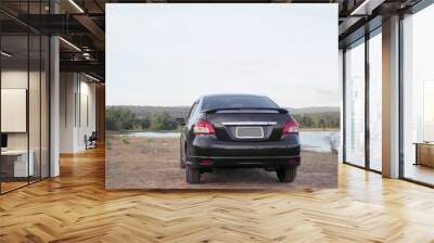 .A black car parked near the reservoir.To picnic Wall mural