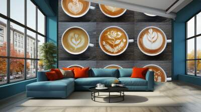 Collection of top view of latte art coffee mugs on timber background. Wall mural