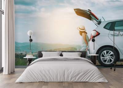 Woman traveler sitting on hatchback car with mountain background in vintage tone Wall mural