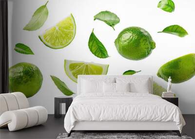 Fresh limes fruits with cut slice and green leaves isolated on background, citrus limes flying in the air. Wall mural