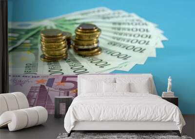 500, 100 euro banknotes and stacks of coins on a blue background. Business concept. Savings concept. Wall mural