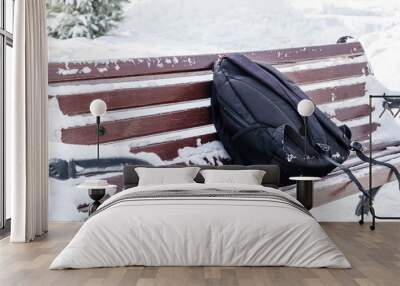 A forgotten backpack on an old, snowy bench in the park Wall mural