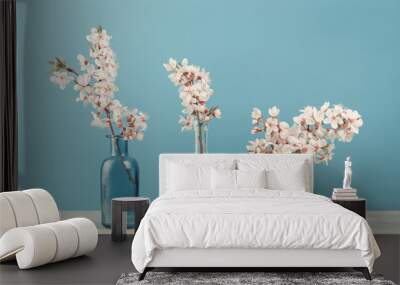 Spring or summer festive blooming with white flowers fruit tree branches in three small glass vases against tender blue background. Fresh floral wide background banner with copy space Wall mural