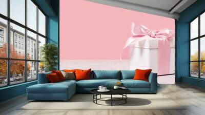 White gift box with shining pink ribbon bow on pink background. Gift or holiday concept. Mothers Day, birthday wedding or St Valentines day banner with copy space Wall mural