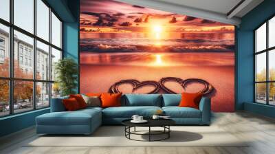 A romantic beach scene at sunset featuring two heart shapes drawn into the smooth sand Wall mural