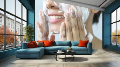 Close up Asian woman smile and washing face by make bubble facial foam and cleansing her face skin Wall mural