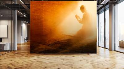 Silhouette religious of muslim male praying in old mosque with lighting and smoke background Wall mural