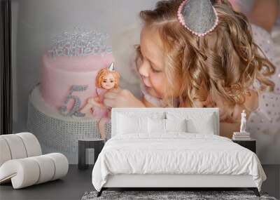 Portrait of a beautiful baby. Little girl looks thoughtfully into the distance. Cheerful mischievous girl. Holiday Birthday. Beautiful little girl laughs.Fashion baby. Five year old baby. Festive cake Wall mural