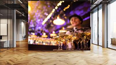 happy waitress holding a tray full of glasses or welcome drinks at an event Wall mural