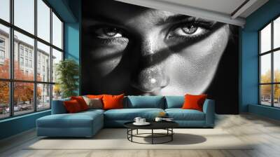 Close-up of a woman face with dramatic shadow play, high contrast black and white background, intense and artistic feel Wall mural