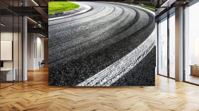 Sharply turning asphalt road, marked by crisp white lines. Wall mural