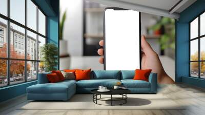 Hand Holding Smartphone Mockup with Blank Screen in Home Office Background Wall mural