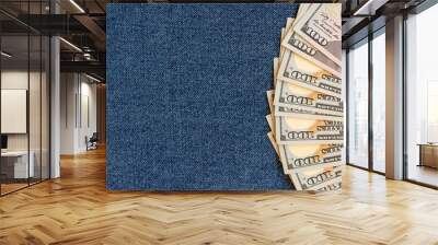 A stack of money on a background of denim. Banknotes are partially visible. Wall mural