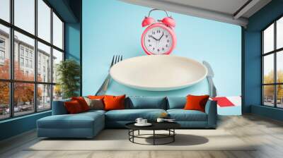 Alarm clockб plate with cutlery and barrier tape. Concept of intermittent fasting, lunchtime, diet and weight loss Wall mural