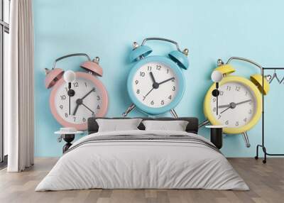 Collection of alarm clocks of different colors show different times. Start of the day, waking up, morning, different time zones. Wall mural