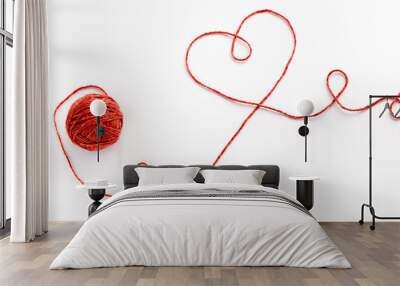 Wool ball and thread in shape of heart on white background Wall mural