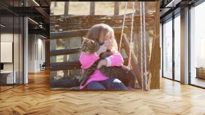 Girl on the swing cuddling a cat. Countryside, village life, tourism Wall mural