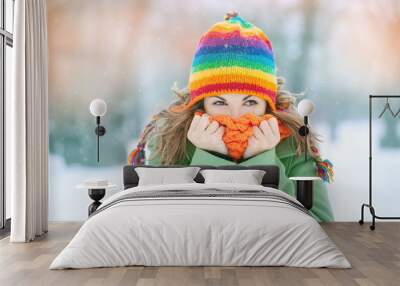 Portrait of a young woman in snow  with scarf on her face trying to warm herself. Winter concept Wall mural