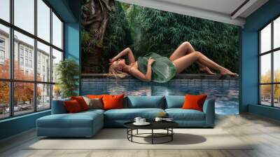 Woman posing near the tropical forest pool with big leaf Wall mural