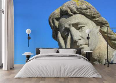 A stone monument to a woman with an extremely sad and tragic expression Wall mural