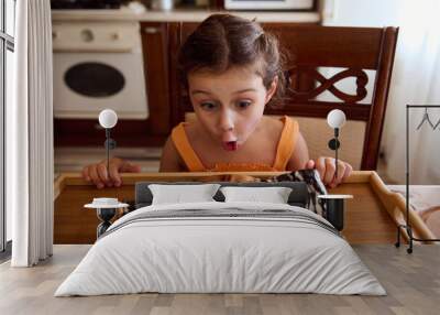 Adorable and funny little girl at home kitchen, admiring a homemade sweet dessert, cherry pie, monastery log Wall mural